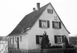 Schwarzweiß-Aufnahme eines Wohnhauses mit Fensterläden